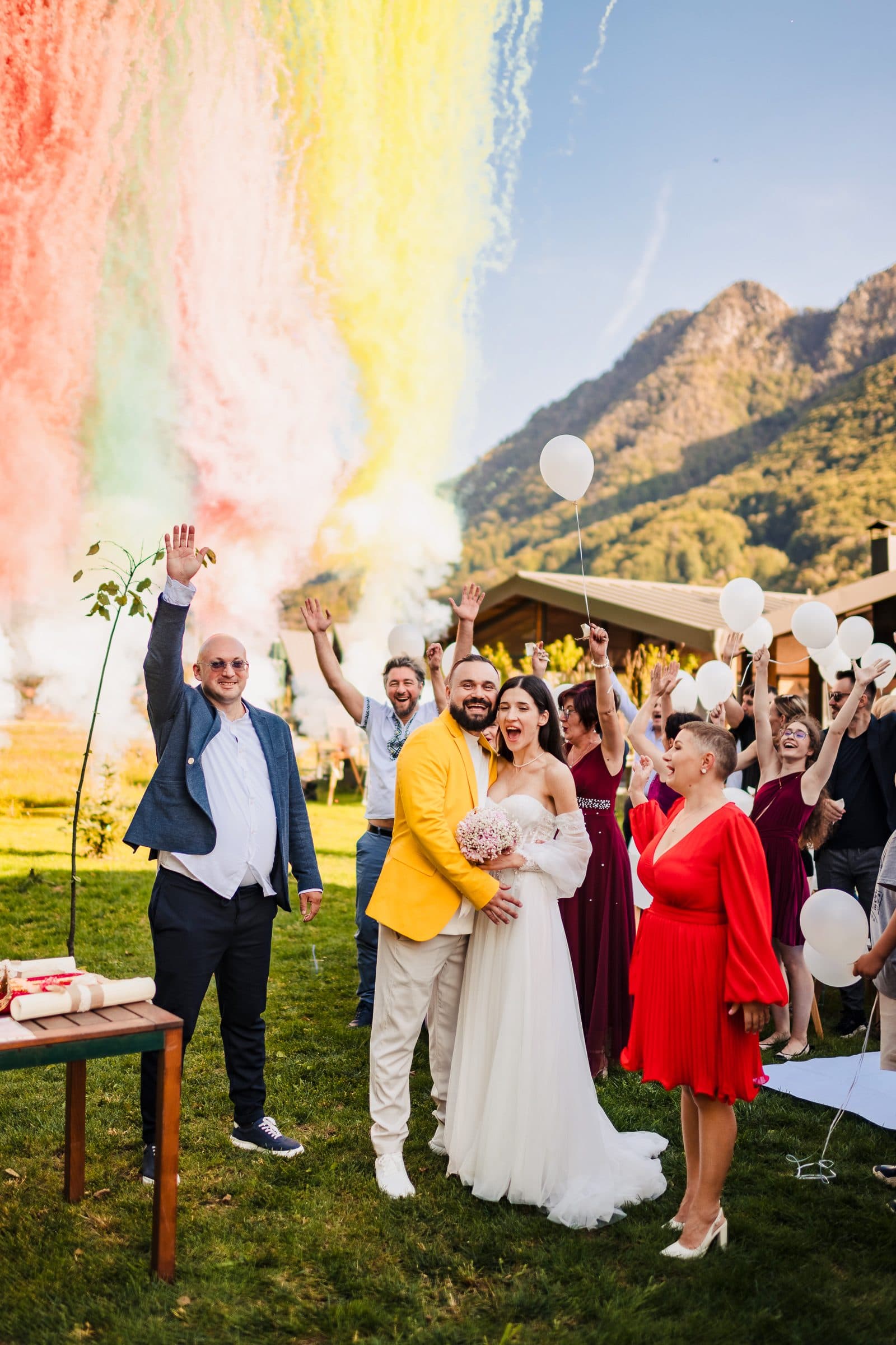 Coloured smoke over the mountains as the couple and their guests cheer with arms raised