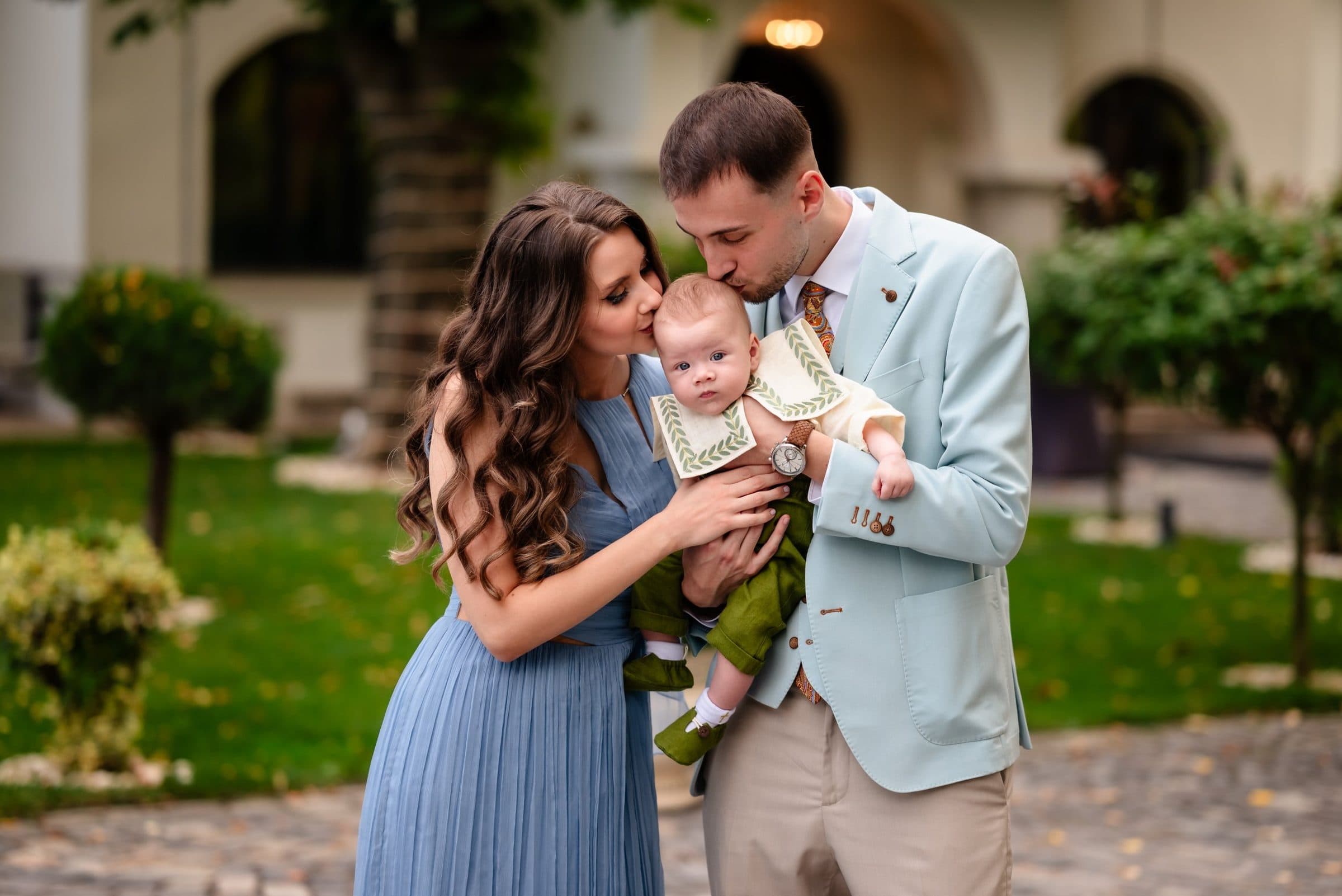 Both parents kiss the baby's head