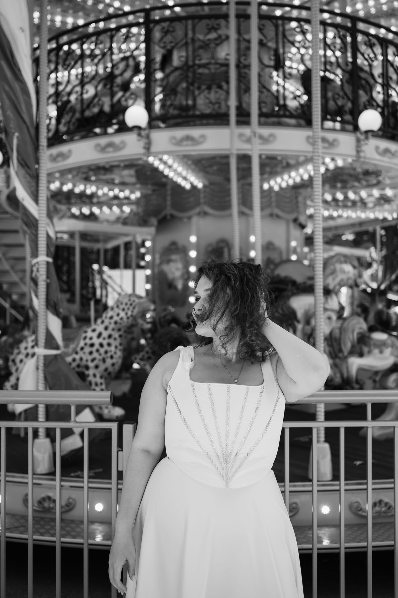 Black and white: the bride turns away in front of the carousel