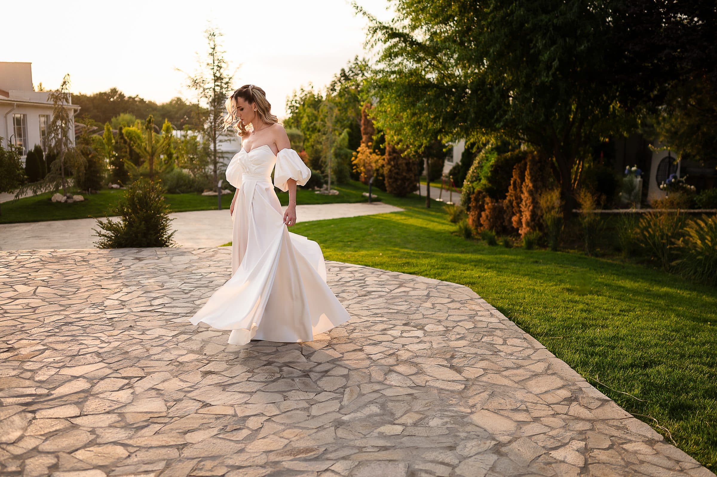 The bride twirls alone on a stone terrace in evening light