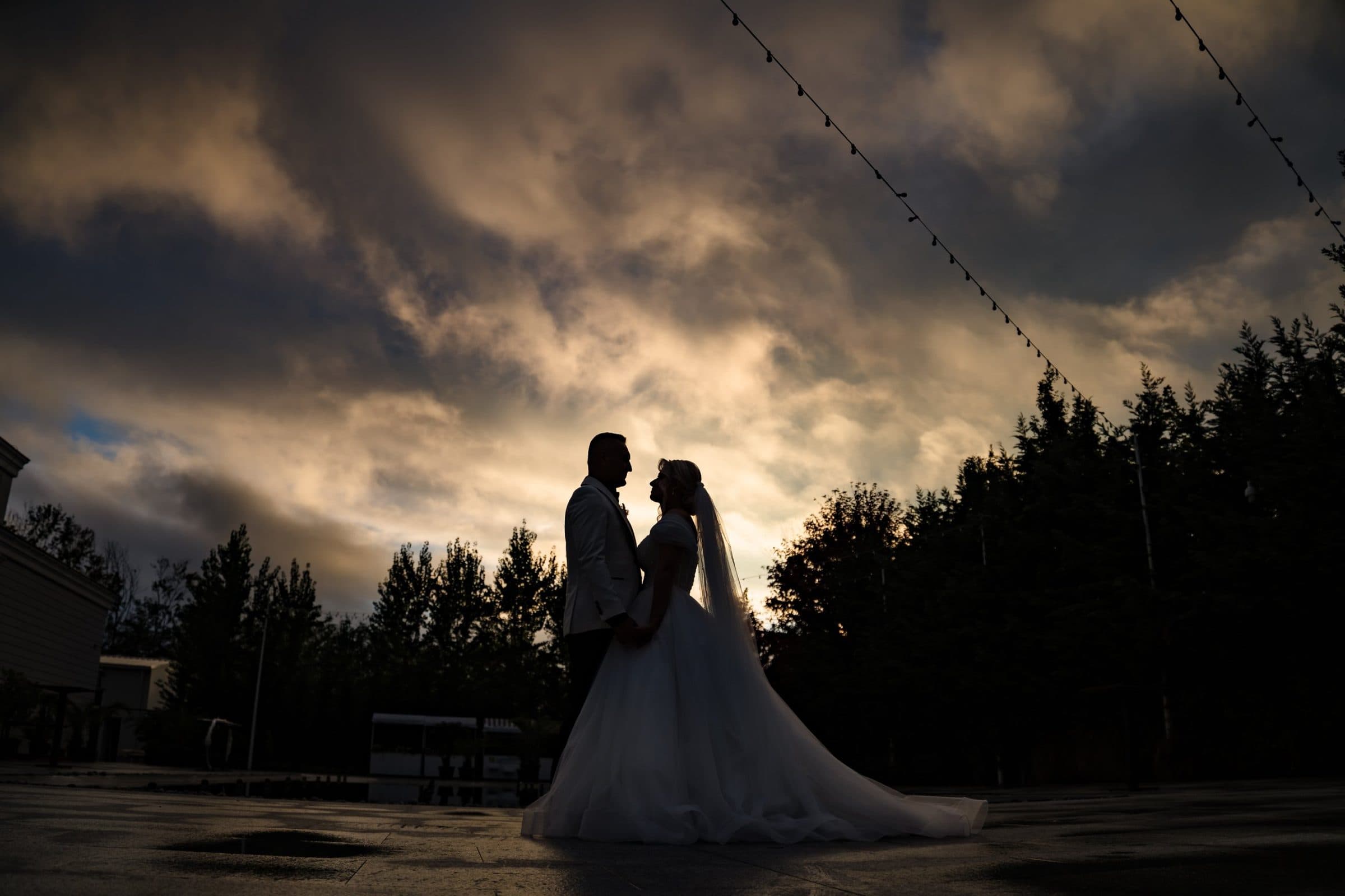 Silhouette of the couple against a dramatic evening sky