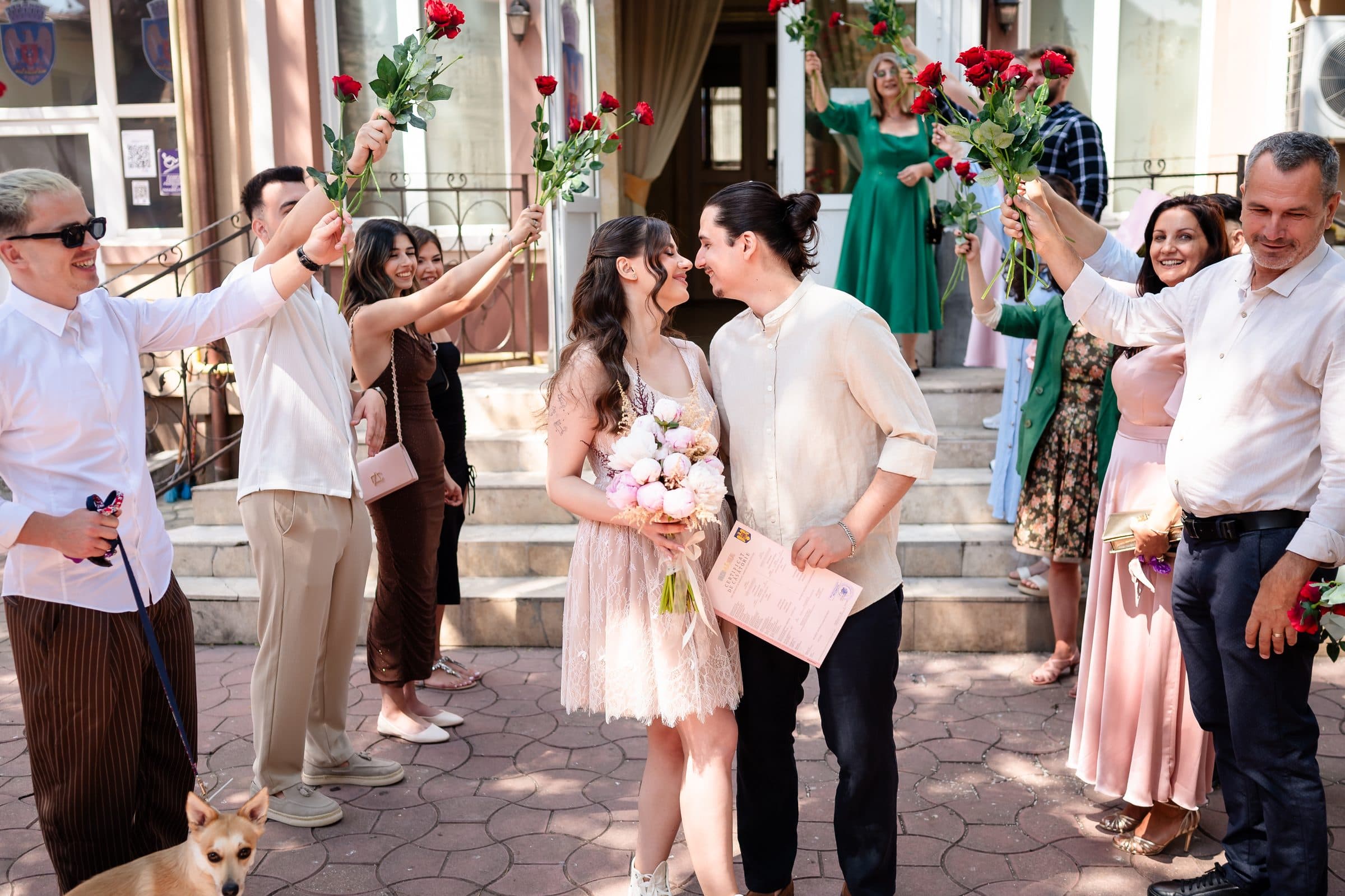 Friends raise roses over the couple as they kiss on the steps after the civil ceremony